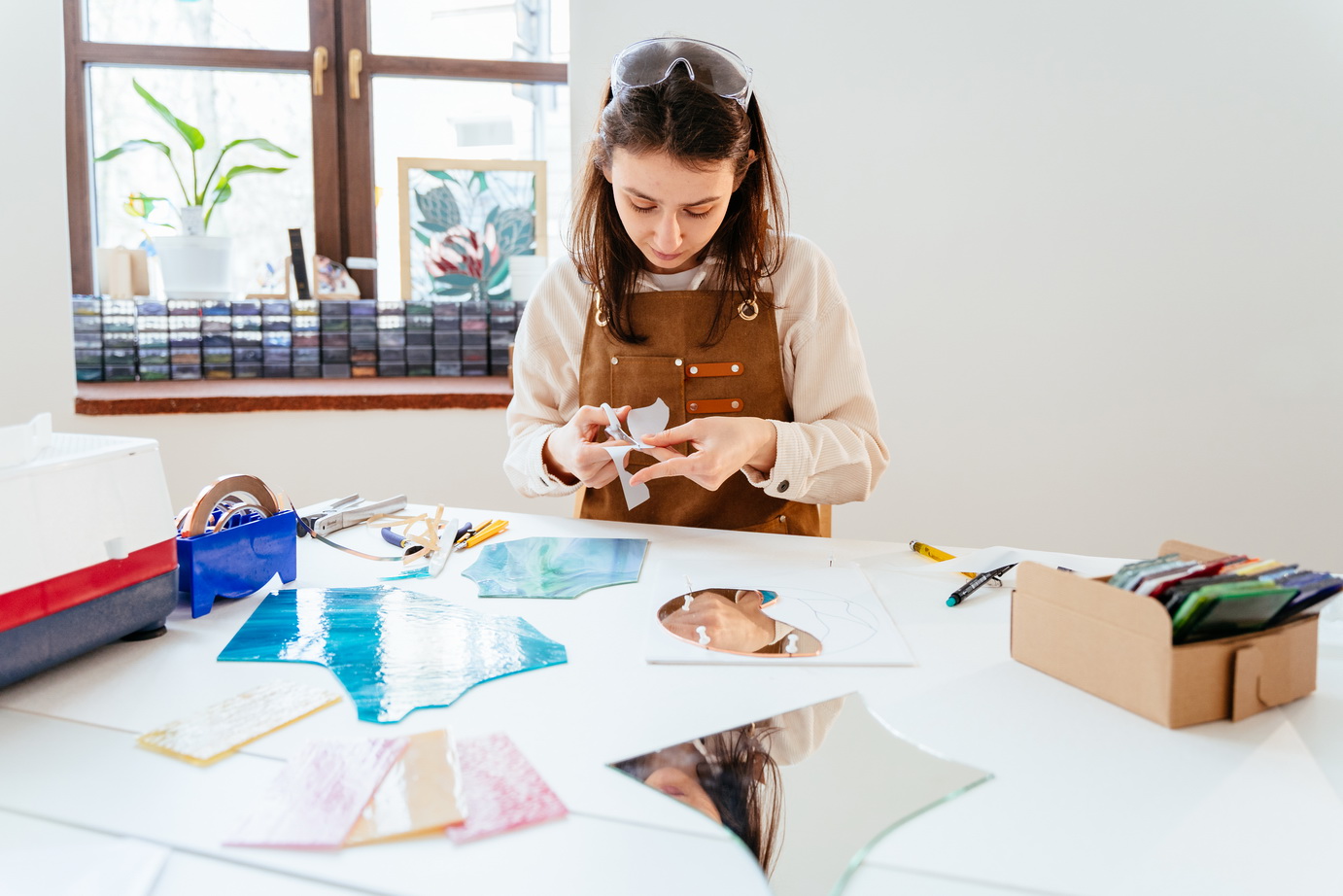 Young female stained glass artists working in studio. Stained glass art, glass work process. Art creative, handmade, Hobbies and crafts concept.